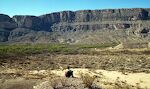 Udsigt over Rio Grande til klippevæggen på den Mexicanske side. I forgrunden ses ruinen af en gammel gård.