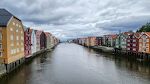 Udsigt fra broen til de farverige bygninger langs Nidelva floden.
