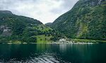 Udsigt til Grande Fjord Hotel og Feriecenter. De, der skal på udflugt til Trollstigen, skal køre op ad den vej, der går i serpentiner bag hotellet.