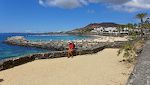 Vi er nået til Playa Flamingo på en tur langs Playa Blancas strandpromenade. I baggrunden ses fyrtårnet Faro de Pechiguera til venstre og Montaña Roja til højre. Vi er nået til Playa Flamingo på en tur langs Playa Blancas strandpromenade. I baggrunden ses fyrtårnet Faro de Pechiguera til venstre og Montaña Roja til højre.